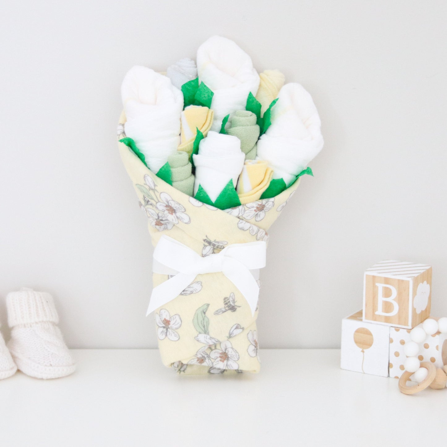 buttercream floral baby girl gift bouquet with diapers onesies socks washcloths