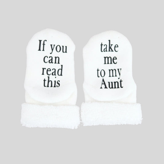 white baby socks with take me to my aunt printed on the bottom