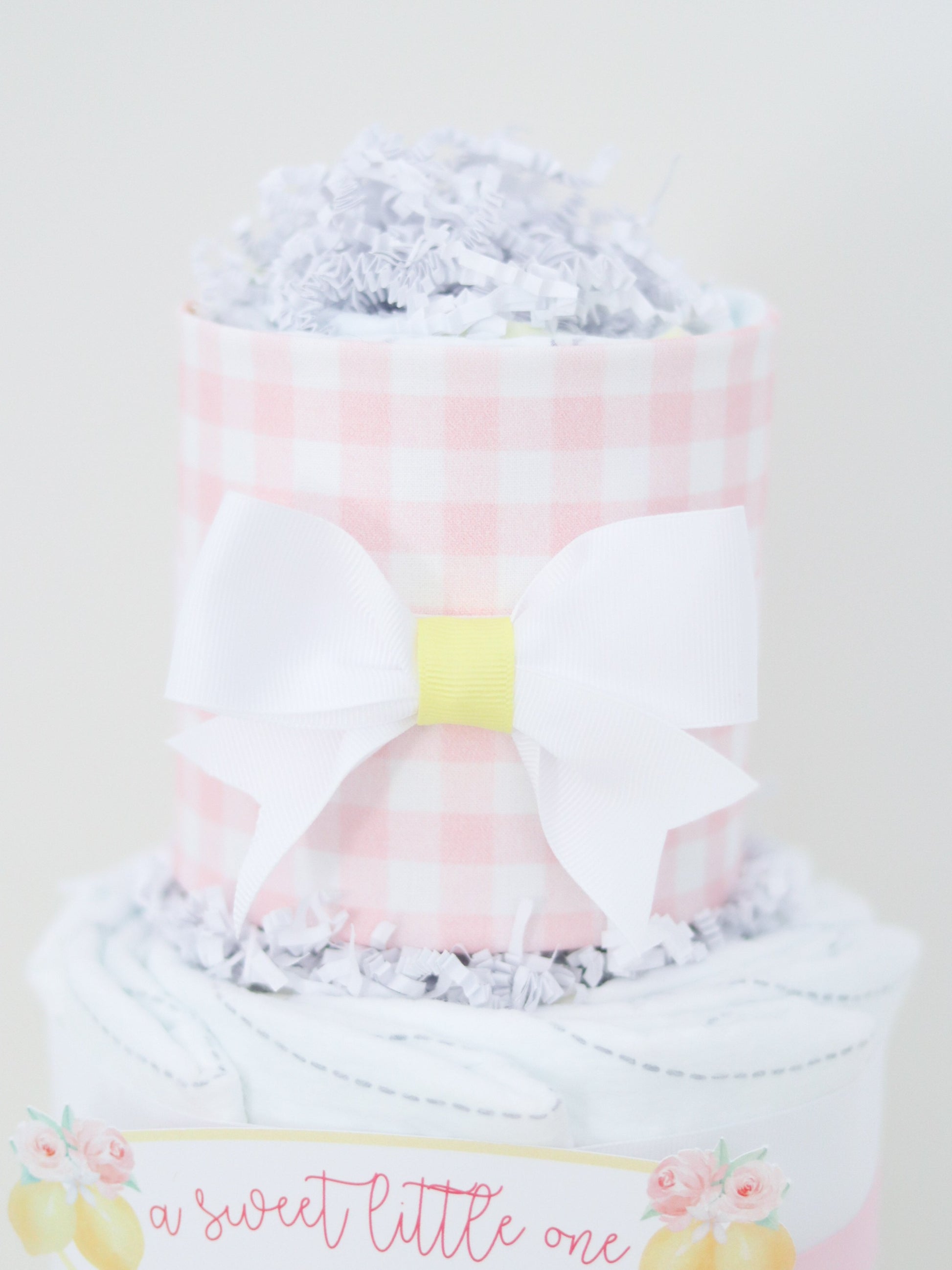 pink gingham diaper cake top with white bow